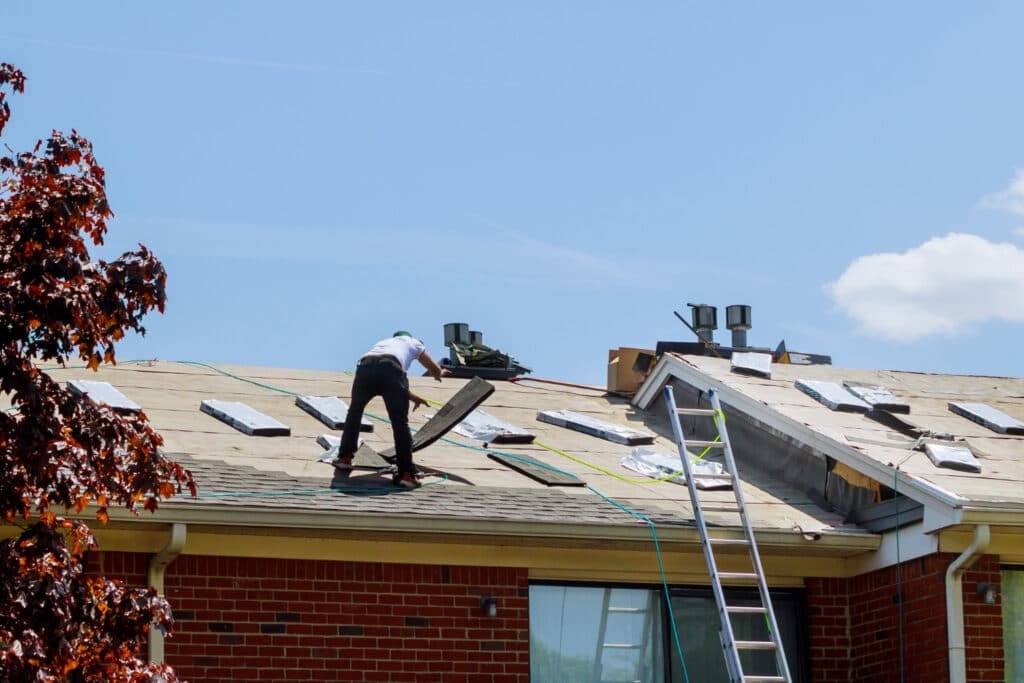 homme debout sur un toit en pleine rénovation